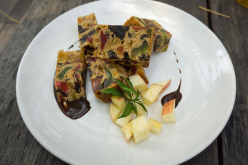 delicious sliced fruit cake with mixed fruit on wooden table
