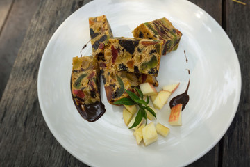delicious sliced fruit cake with mixed fruit on wooden table