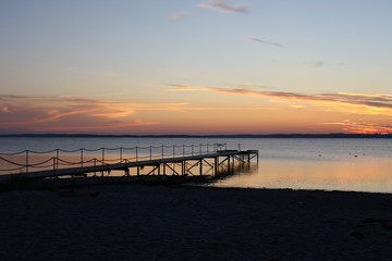 Obraz premium Seebrücke am Meer. Im Hintergrund sieht man den Sonnenuntergang.