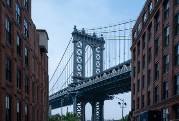Closeup of Manhattan Bridge between two brown Buildings