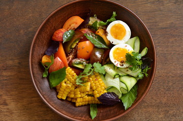 Corn salad with vegetables and boiled egg, top view, copy space