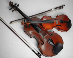 Fototapeta na wymiar Two violins put on background,show detail and different size of acoustic instrument