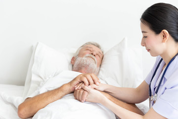 Obraz premium Nurse cares for elderly man sleeping in bed