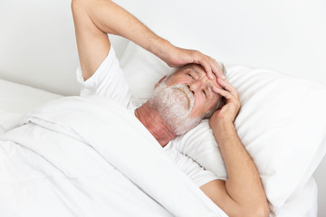 Worried senior retirement man lying awake in his bed