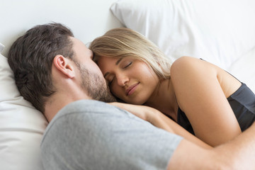 Obraz na płótnie Canvas Young cute couple hug and sleep together in bed