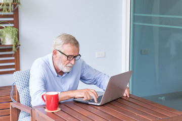Senior retirement man is working with his laptop at home feeling unhappy