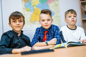 Schoolchildren on the lesson in primary school. Boys looking at camera. Selective focus.