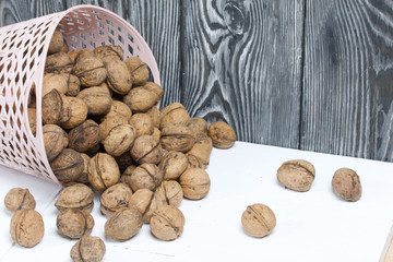 An overturned basket of walnuts. Against a background of painted pine boards.