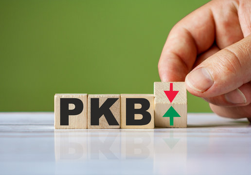 Polish word PKB ( english GDP ) symbol concept and hand turn wooden block and change red arrow
