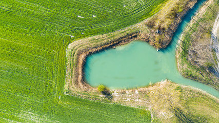Aerial drone view of green field and lake