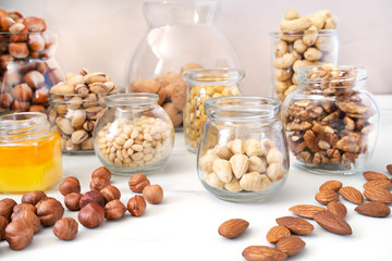 Different nuts (hazelnuts, cashews, pistachios, pine nuts, walnuts, almonds and chickpeas) in glass...