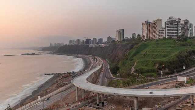 Aerial view of Lima's Coastline in the neighborhood of Miraflores during sunset timelapse with orange light, Lima, Peru. Road traffic with junction and beach with ocean from Husares De Junin