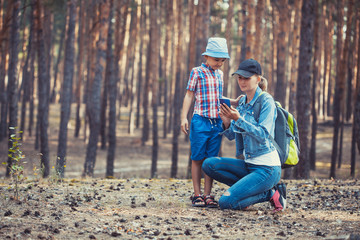 mom and son are walking in a pine forest. Tourism, outdoor activities