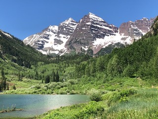 Turquoise, Blue and Green Colors of Maroon Bells Lake with pine trees in background at Maroon Bell Scenic Recreation Area, Maroon Bells Amphitheater near Aspen Highlands Ski Area