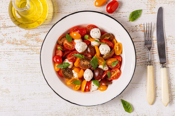Traditional Caprese salad made of sliced fresh tomatoes, mozzarella cheese and basil