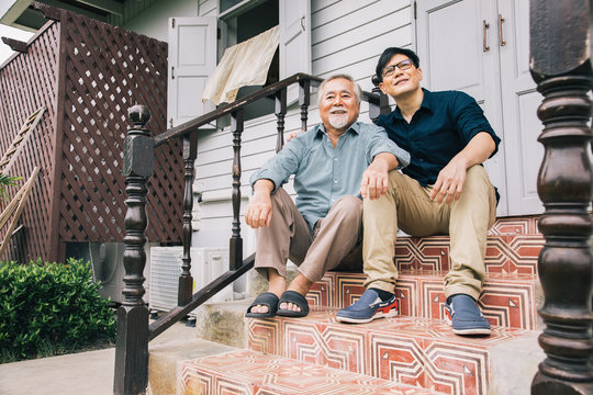 Family of an elderly couple are communicating with handsome son and watching memories on the stairs. Concepts about learning and stress relaxation
