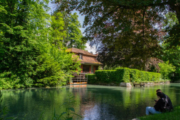 Fototapeta premium garden with a pond and a beautiful house in Switzerland