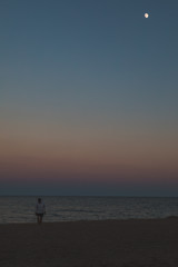 Fototapeta na wymiar man standing at sea beach looking at moon