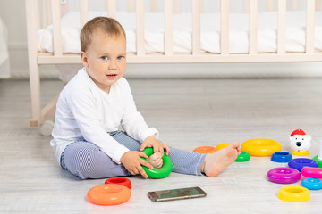 little boy 2 years old playing near the crib, early development