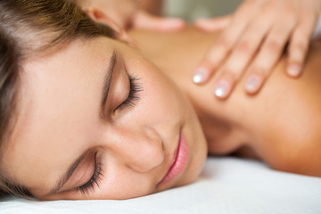 Obraz na płótnie Canvas Young woman getting a massage in a spa