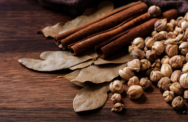 white cardamom with bay leaf and cinnamon on wooden table