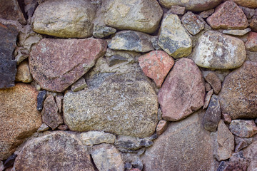 Texture of a stone wall made of large and medium-sized stones