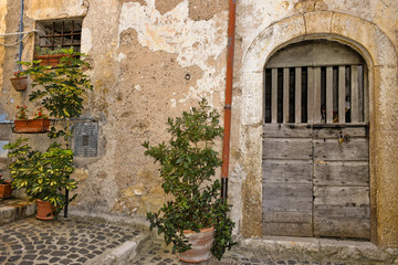 Plakat A narrow street among the old houses of Giuliano di Roma, a rural village in the Lazio region.