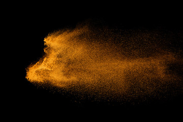 Fototapeta na wymiar Closeup of orange powder particle splash isolated on black background.