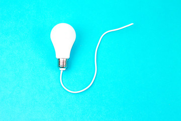 A :Switched on light bulb on a light blue background - a symbol of a new idea, innovation