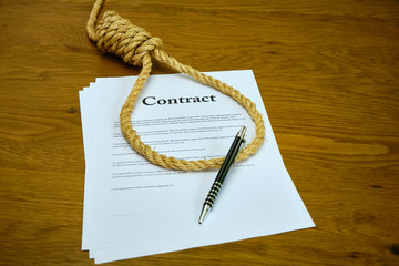 Contract with pen and rope tied in hangmans noose. Strangulation contract, unfair agreement.
