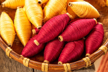 natural colour of red and yellow cotton spools of thread use for weaving textile with tradition loom