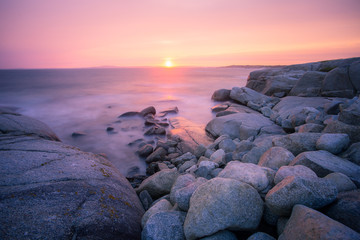Fototapeta na wymiar A beautiful sunset on the rugged Atlantic shoreline with sun at the horizon