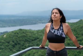 Mujer joven respira mientras el viento golpea su rostro.