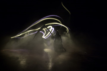 Death with a scythe in the dark misty forest. Woman horror ghost holding reaper in forest,...