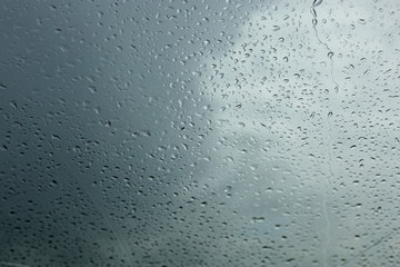 dripping raindrops on the glass of a car