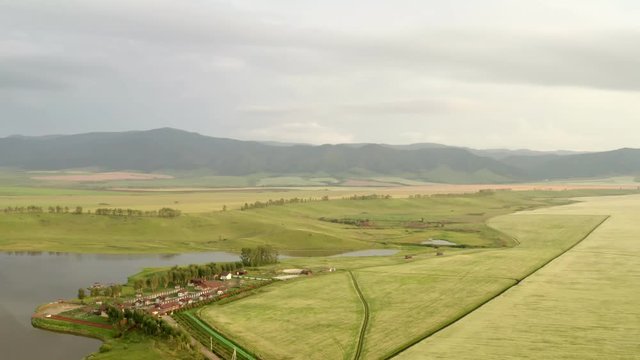 Scenic aerial panoramic view of idyllic rolling hills spring landscape in with lush green mountain pastures in evening light at sunset