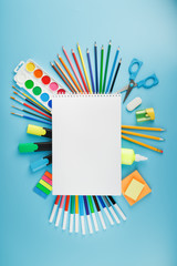 An album of brushes and paints with school supplies on a blue background. Album, a place to copy...