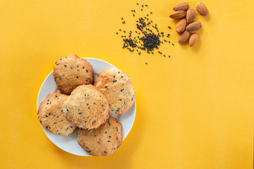 Homemade cookie with almond and black sesame on yellow background