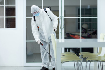 Male medical staff wearing PPE suits to protect against COVID-19 using nebulizers. And use chemicals disinfecting in kitchens.