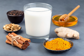Ingredients for turmeric moon milk on concrete background, horizontal