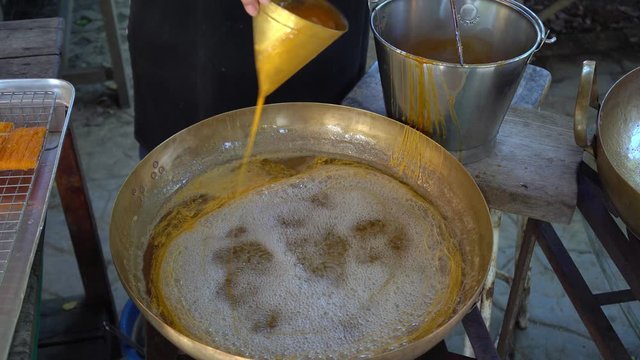 woman making golden egg yolk thread or Foi Thong which is Thai dessert
