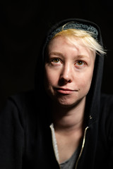 Portrait of a young woman with short blonde hair smiling upward.