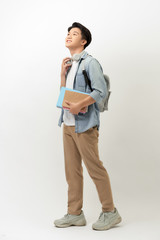 Smiling teenager with a schoolbag standing on wall background
