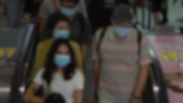 Slow motion blurred defocused view of taiwaneses travellers wear mask at entrance escalator of metro station to prevent infection coronavirus. Virus caused emergency situation arround world-Dan
