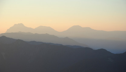 sunset in mountains. peaks and hills against clean sky