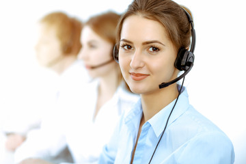Call center. Focus on beautiful business woman in headset