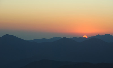 sunset in mountains. peaks and hills against clean sky