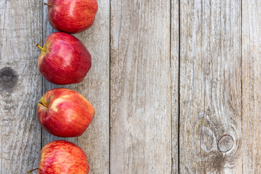 Red apples on a wooden background. Copy space.