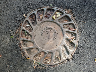 Cast iron cover of the manhole leading to the sewer. On the hatch, the Russian inscription "GOST" (means Gosstandart of production) and the number of the standard.