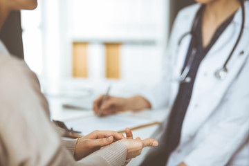 Doctor and patient discussing current health examination while sitting in clinic. Perfect medical...